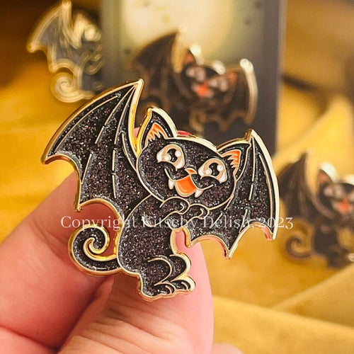 Bat-shaped decorative item held by a hand with blurred background
