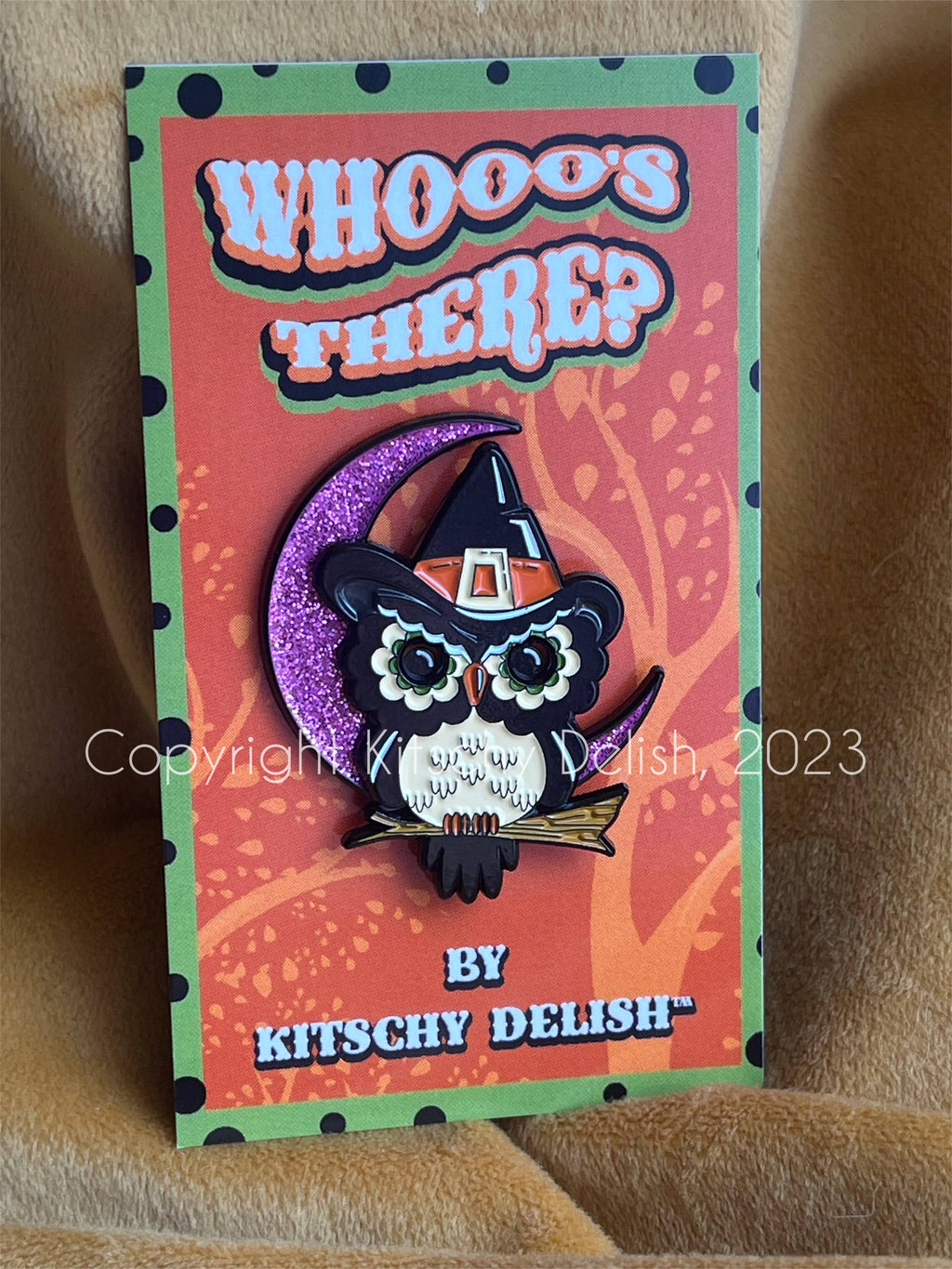 Halloween-themed pin with an owl in a witch hat on a colorful card by Kitschy Delish.