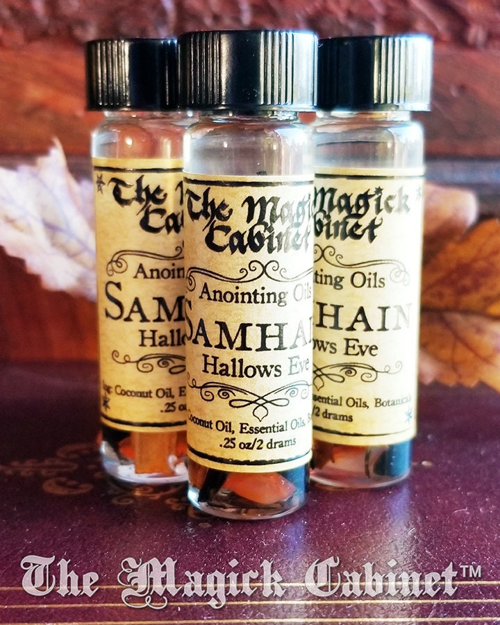 Three small bottles with labels from 'The Magick Cabinet' on a wooden surface.