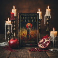 Amber Moon Tarot card set packaging with a woman in a field of flowers and a red moon.
