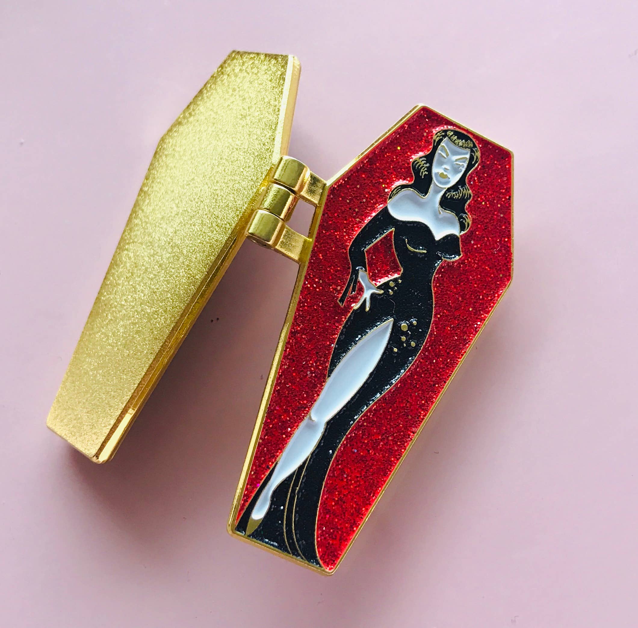 Coffin-shaped enamel pin with a woman design on a pink background