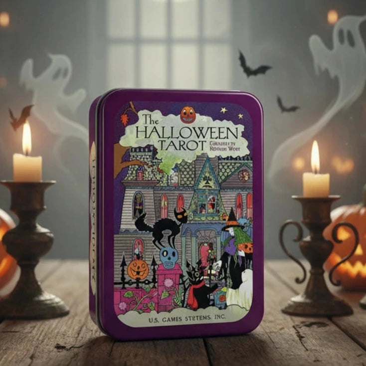 The Halloween Tarot deck in a purple metal tin box, featuring a detailed illustration of a haunted house and Halloween characters on the front cover. The text 'The Halloween Tarot Created by Kippling West' 