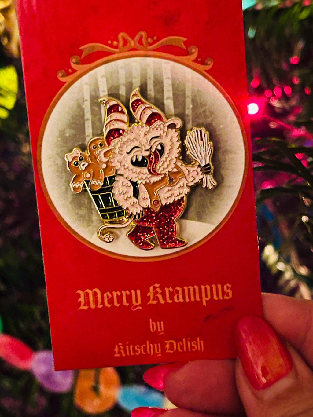 Merry Krampus pin by Kutschy Delish on a red card with Christmas decorations in the background.