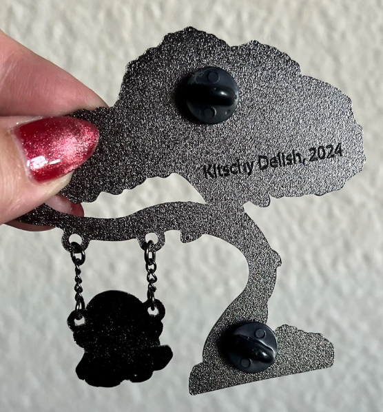Black decorative squirrel ornament with 'Kitschy Delish, 2024' text on a textured white background.